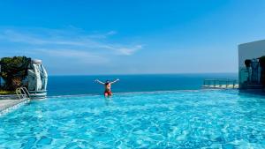 a person standing in the water in a swimming pool at Apec Mandala Luxury Phú Yên in Tuy Hoa
