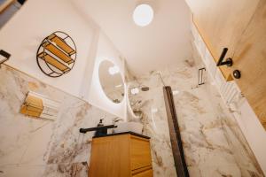 Un baño con lavabo y paredes de mármol. en Arad City Escape AFI Mall, en Arad 21 fotos más