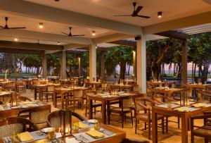 an empty restaurant with wooden tables and chairs at Jetwing Beach in Negombo