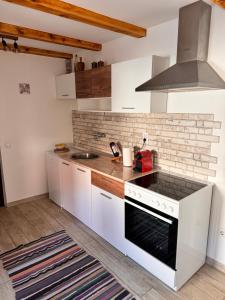 a kitchen with white cabinets and a stove top oven at Johnny Apartment in Belgrade +16 photos