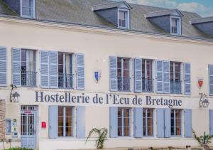 a building with blue shutters and a sign on it at Hostellerie de l'Écu de Bretagne in Beaugency