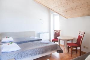 a bedroom with two beds and a table and chairs at Noclegi Sebastian w Centrum in Ustrzyki Dolne