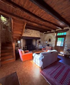 a living room with a couch and a fireplace at L'écrin de verdure - Vue imprenable - Piscine in Cénac-et-Saint-Julien