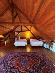 a large room with two beds and a rug at L'écrin de verdure - Vue imprenable - Piscine in Cénac-et-Saint-Julien