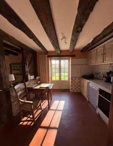 a kitchen with a table and chairs and a window at L'écrin de verdure - Vue imprenable - Piscine in Cénac-et-Saint-Julien