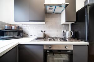 a kitchen with a sink and a stove top oven at Spacious Apartment With A Terrace Style Rooftop in Cleveleys +12 photos