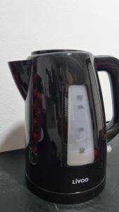 a black coffee pot with a white at Appartement de luxe lac 2 in Tunis