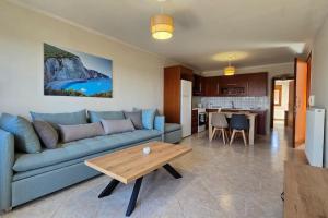 a living room with a blue couch and a table at Calliestia 7 in Chios