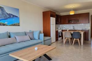 a living room with a blue couch and a kitchen at Calliestia 7 in Chios