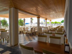 a restaurant with white chairs and tables and tablesktop at Sun Fire Beach Hotel - All Inclusive in Alanya