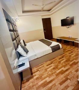 a bedroom with a bed and a flat screen tv at Hotel Airport City in New Delhi