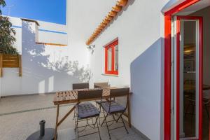 un patio con tavolo e sedie in una casa di Casa Maria Rota ad Aljezur