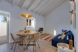 un soggiorno con un tavolo e un divano blu di Casa Maria Rota ad Aljezur