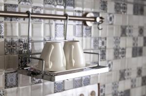 a group of white vases on a shelf in a bathroom at Garsonieră Centru Petroșani in Petroşani