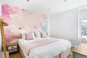 a bedroom with a bed with a pink and white wall at Stylish Flat with Stunning Sea Views Ilfracombe in Ilfracombe