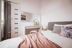 biała sypialnia z łóżkiem i kominkiem w obiekcie Ottimo Apartamenty Floriana w Bydgoszczy