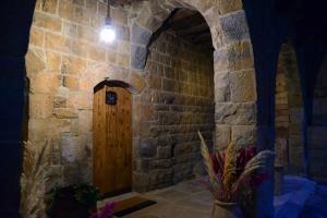 a room with a wooden door in a stone wall at Bayt Wadad, Bcharre Lebanon in Bcharré