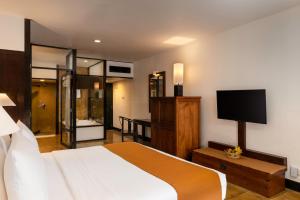 a bedroom with a large bed and a television at Jetwing Beach in Negombo
