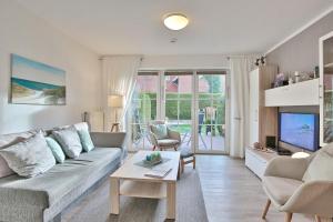ein Wohnzimmer mit Sofa und Fernseher in der Unterkunft Residenz Alte Bergstraße Residenz Alte Bergstrasse Appartement 5 in Scharbeutz