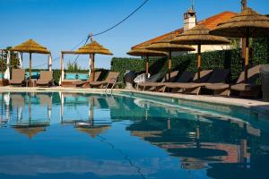 a swimming pool with chairs and umbrellas at Boutique Hotel & Spa la Villa Cap Ferrat in Saint-Jean-Cap-Ferrat