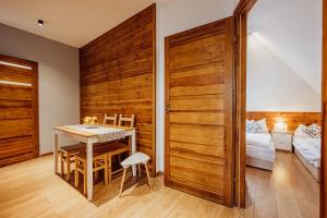 a dining room with a table and a bed at Apartamenty Przygoda w Karpaczu in Karpacz