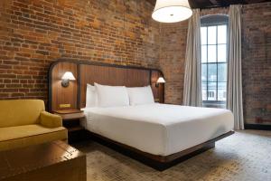 法兰克福The Delegate Hotel的一间带大床和砖墙的卧室 更多37张照片