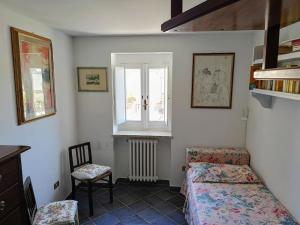 a bedroom with a bed and a window and a chair at Casa Scilla in Trani