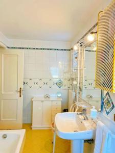 a bathroom with a sink and a mirror and a tub at Casa Scilla in Trani