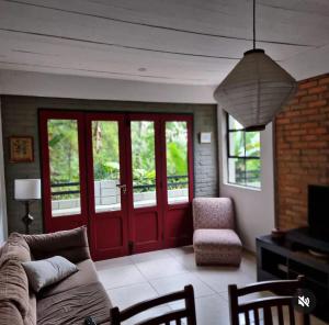 - un salon avec un canapé et une porte rouge dans l'établissement Casa charmosa e espaçosa, à Tiradentes