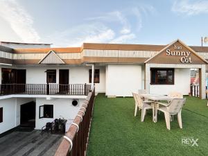 a building with a patio with a table and chairs at Hotel Sunny Cot - Free Mall Shuttle and Parking in Mussoorie