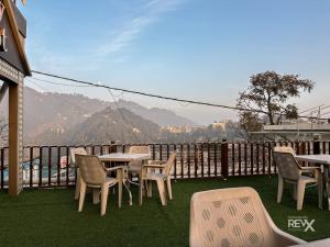 a group of tables and chairs on a balcony at Hotel Sunny Cot - Free Mall Shuttle and Parking in Mussoorie
