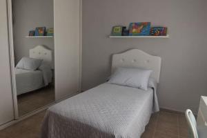 mała sypialnia z łóżkiem i lustrem w obiekcie Casa Emma w mieście Poblete +18 zdjęć