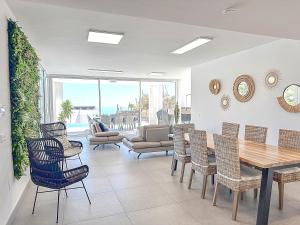 a living room with a dining room table and chairs at Villa BuenaVista Hills - Sea View - Infinity Pool - Parking - Grill in Málaga +28 photos