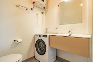 a bathroom with a washing machine and a sink at Baia di Spartaia 1 in Procchio