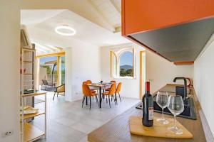 a kitchen and living room with a table with wine glasses at Baia di Spartaia 1 in Procchio