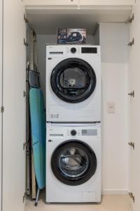 a washer and dryer with a surfboard in a closet at Palazzo Cavour, 34 - Luxury Suite Decumano in Pavia