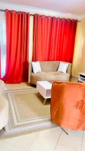 a living room with red curtains and a couch at Nappers Secrets in Kampala