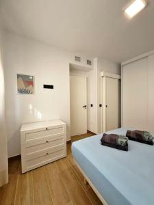 biała sypialnia z łóżkiem i komodą w obiekcie Nuevo y céntrico apartamento de playa w mieście Fuengirola