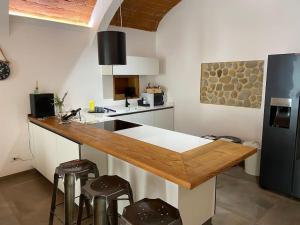eine Küche mit einer Theke mit Hockern und einem Kühlschrank in der Unterkunft Magda house in Montelupo Fiorentino