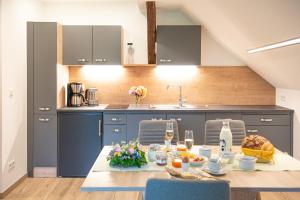 a kitchen with blue cabinets and a table with food at Feuerlehof Appartement in Aigen im Ennstal