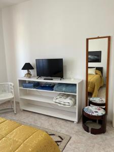 a white entertainment center with a television on top of it at Casa Ubi in Quartu SantʼElena