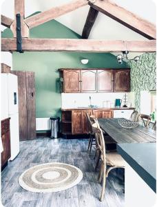 a kitchen with a table and chairs in a room at The Coach House in Berriew +8 photos