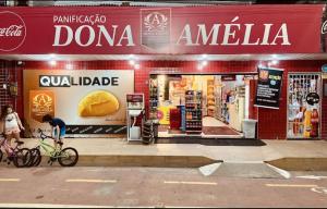 a person riding a bike in front of a store at Hotel e Pousada Encanto dos Corais Maceió in Maceió