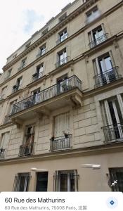 BerthouvilliersCozy appartement near Opera and Galeries Lafayette Haussmann的一座大型建筑,设有窗户和阳台