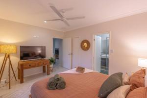 a bedroom with a bed and a flat screen tv at Coconut Cove Trinity in Trinity Beach
