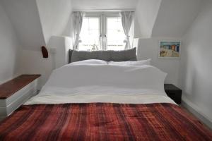 un grand lit blanc dans une chambre avec une fenêtre dans l'établissement Sailmaker's Cottage, à Shaldon