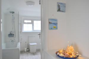 La salle de bains est pourvue d'une douche et d'un lavabo. dans l'établissement Sailmaker's Cottage, à Shaldon 9 autres photos