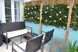 - une terrasse avec 2 chaises, une table et des fleurs dans l'établissement Sailmaker's Cottage, à Shaldon