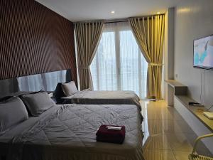 a hotel room with two beds and a window at Apartemen Nagoya Thamrin Tower B lvl 12 Free Netflix in Nagoya