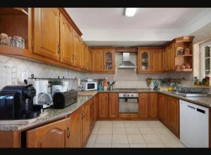 a kitchen with wooden cabinets and white appliances at Spacious villa with private pool in Grândola in Grândola +22 photos